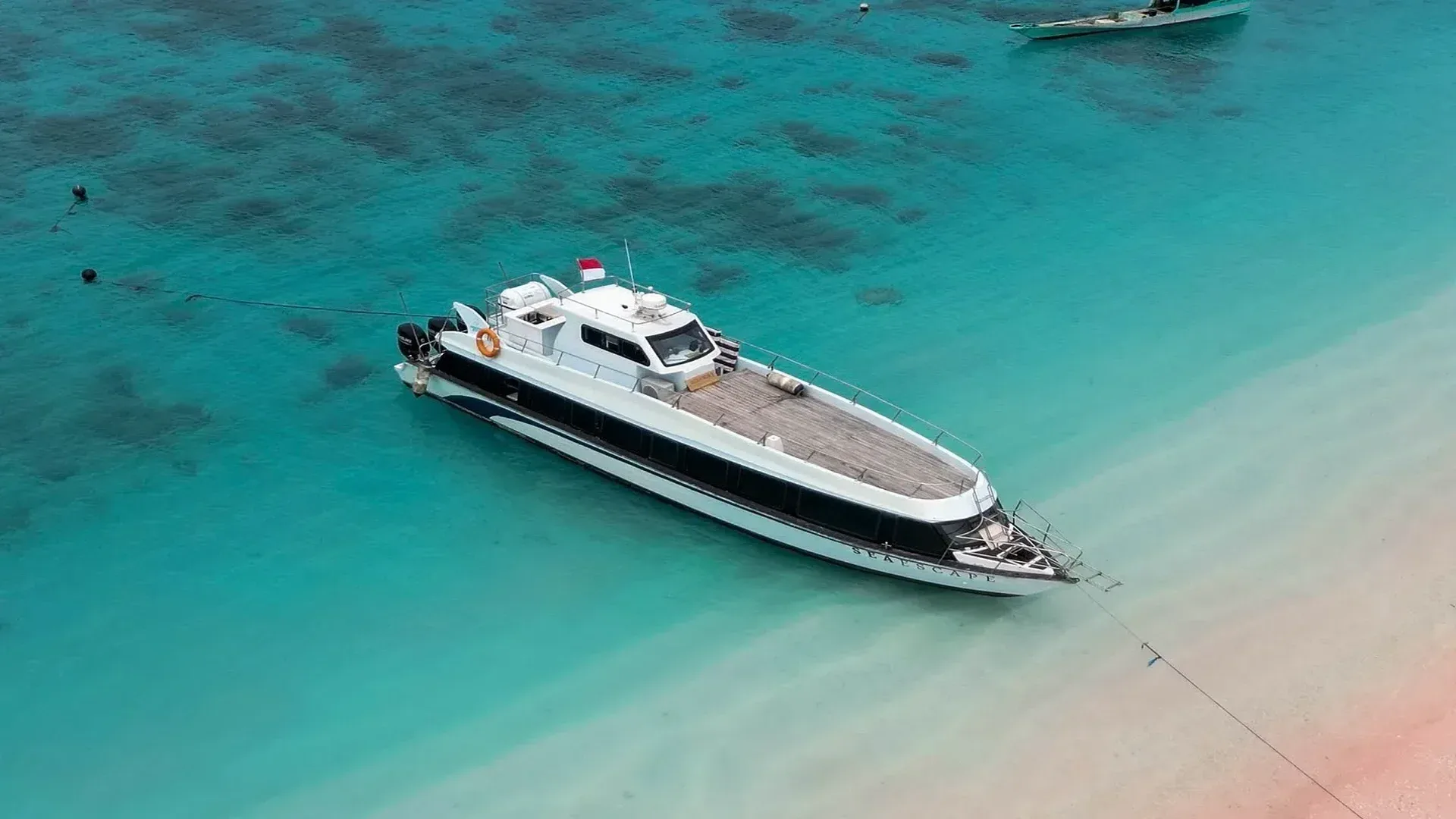 Private speedboat cruising past green hills in Komodo National Park